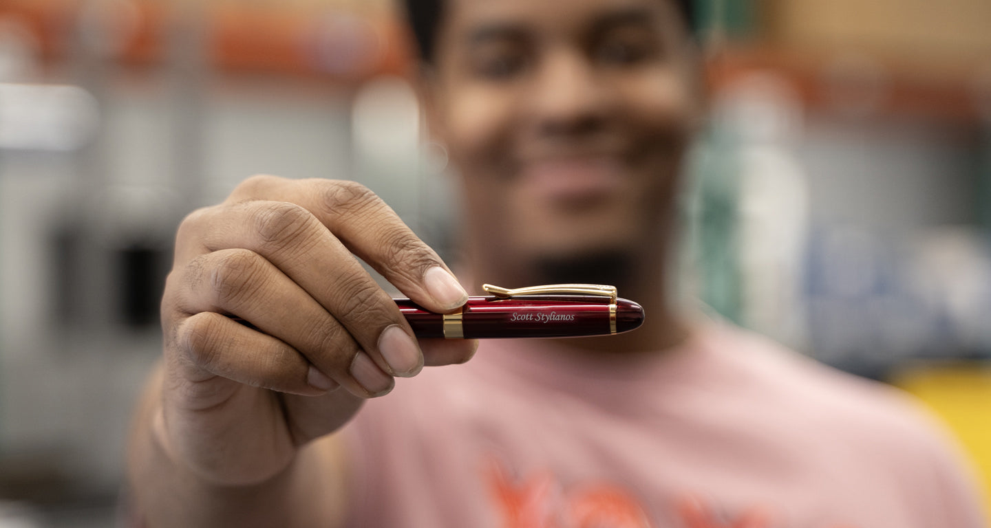 A man holding the Alexandria Red Rollerball custom engraved